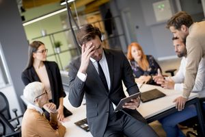 Stressed executive tries to calm nerves in a meeting